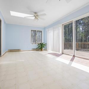 Sunroom overlooks the rear deck and fenced yard.